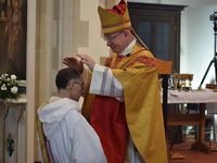 Bishop Richard Moth laying hands on the head of a kneeling deacon at his ordination to the Priesthood