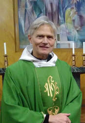 Canon Tom Treherne, Parish Priest, vested in green and standing in front of the altar in St Richard's Church.