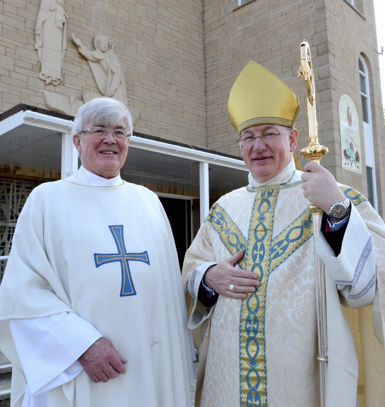 Fr John pictured with Bishop Richard, who is wearing a gold mitre and holding his crozier. Both are smiling and vested for Mass.