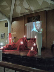 The sanctuary at St Richard's decorated in red and lit by candles, for the Stations of the Cross led by the Confirmation group. A projected image is on the back wall, representing Jesus.
